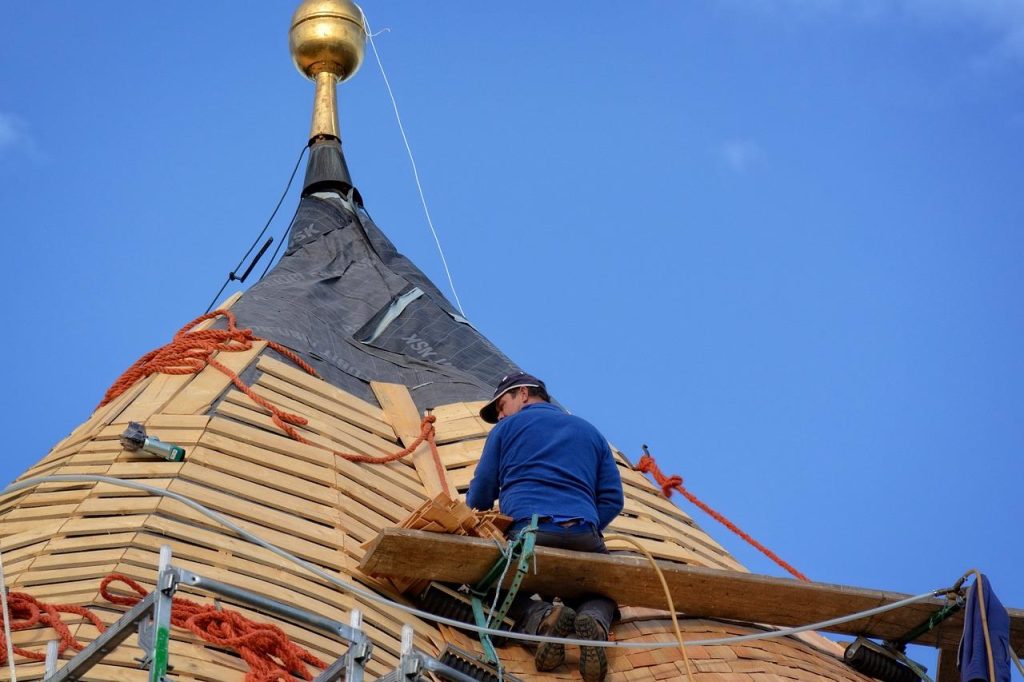 Professionele dakdekker in Ridderkerk voert dakonderhoud en reparaties uit aan een dak